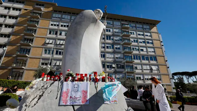 Doctors sit in front of the statue of John Paul II at the entrance to the Gemelli Hospital, where Pope Francis is hospitalized, in Rome, Italy, 18 March 2025. ANSA/FABIO FRUSTACI