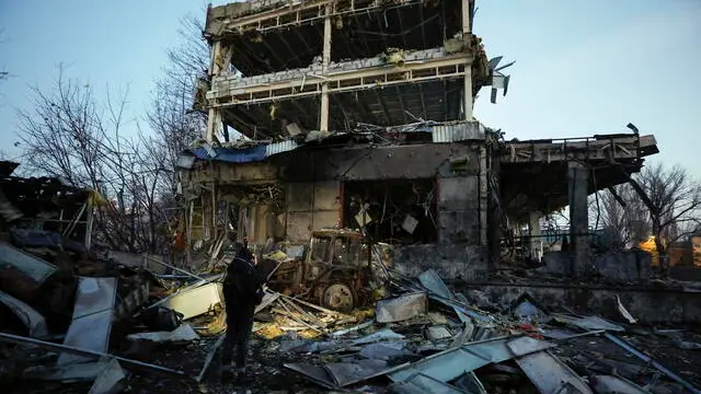 epa11889975 People look at the site of a Russian missile strike in Kyiv, Ukraine, 12 February 2025 amid the Russian invasion. At least one man was killed and four others, including one child, were injured in a Russian attack involving missiles and shock drones in Kyiv, according to the State Emergency Service of Ukraine (SESU). EPA/SERGEY DOLZHENKO