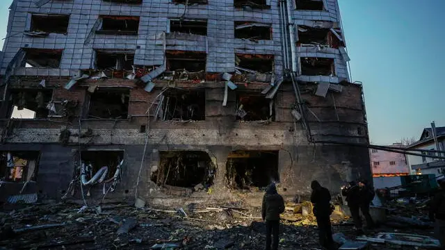 epa11889984 People look at the site of a Russian missile strike in Kyiv, Ukraine, 12 February 2025, amid the Russian invasion. At least one man was killed and four others, including one child, were injured in a Russian attack involving missiles and shock drones in Kyiv, according to the State Emergency Service of Ukraine (SESU). EPA/SERGEY DOLZHENKO