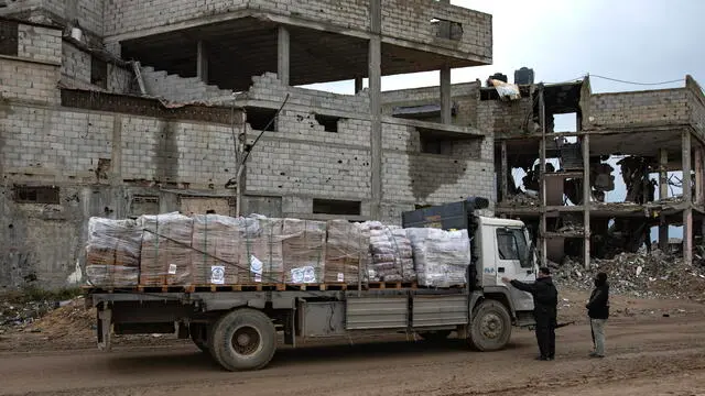 epa11921658 People stand next to a truck carrying humanitarian aid along Salah al-Din road, amid a ceasefire between Israel and Hamas, in Rafah, southern Gaza Strip, 24 February 2025. According to the United Nations Relief and Works Agency for Palestine Refugees (UNRWA), thousands of trucks carrying essential humanitarian aid have crossed into the Gaza Strip since the first phase of a six-week ceasefire deal between Israel and Hamas came into effect on 19 January 2025. EPA/HAITHAM IMAD