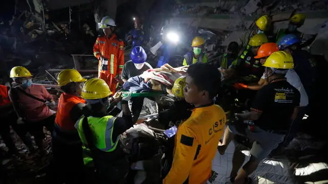 epa11999806 Rescuers carry a victim from the scene at the Sky Villa in Mandalay, Myanmar, 30 March 2025. More than 1,600 people have been killed and thousands injured after a 7.7-magnitude earthquake struck the country on 28 March , according to the Myanmar government. EPA/NYEIN CHAN NAING