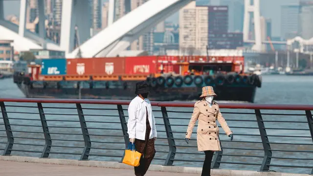 epa12007038 People walk on the river bank while cargo ships sail on the Huangpu River in Shanghai, China, 03 April 2025. On 02 April 2025, US President Trump announced 34 percent tariffs on Chinese goods imported into the US. The tariff is in addition to an existing 20 percent tariff on US imports from China, making the total rate 54 percent, which is expected to go into effect on 09 April 2025. China's Ministry of Commerce stated on 03 April 2025 that China would introduce countermeasures and urged the US to cancel the tariffs. EPA/ALEX PLAVEVSKI