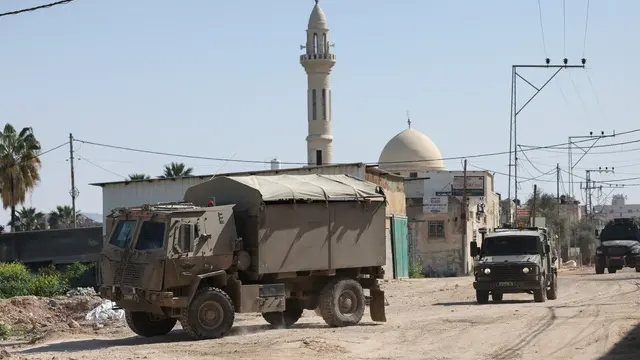 epa11955262 Israeli military vehicles travel along a road during an Israeli military operation in the West Bank city of Jenin, 11 March 2025. According to the Palestinian Ministry of Health, three people were killed so far today during the Israeli military operation in Jenin. The Israeli military launched a military operation in Jenin and its camp on 21 January, resulting in at least 34 Palestinian deaths and dozens of injuries, according to the Palestinian Ministry of Health. EPA/ALAA BADARNEH