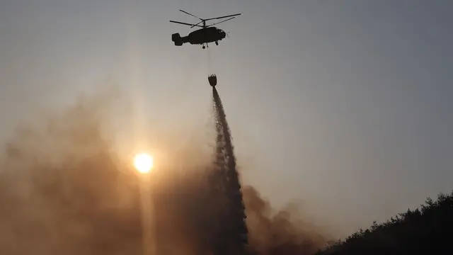epa11996374 A firefighting helicopter drops water to extinguish a wildfire in Andong, North Gyeongsang Province, South Korea, 29 March 2025. South Korea is grappling with wildfires in the southeastern region, described by authorities as the largest on record, with at least 26 people killed, according to the Central Disaster and Safety Countermeasure Headquarters. EPA/YONHAP SOUTH KOREA OUT