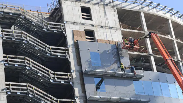 Operai edili allestiscono panneli sulla facciata di un edificio in costruzione, 2 novembre 2020.In LOmbardia l'edilizia, dopo lunghi anni di pesanti perdite, registra una variazione del numero di imprese attive prossima al valore nullo (-0,2%) e vede la possibilità concreta di un ritorno alla crescita. ANSA/DANIEL DAL ZENNARO