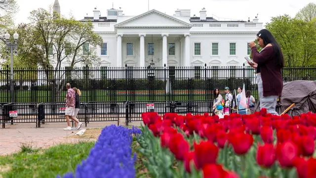 epa12009782 Tourists on Pennsylvania Avenue walk next to anti-scale fencing that has been erected ahead of weekend protests against the Trump administration at the White House in Washington, DC, USA, 04 April 2025. The nationwide day of action against President Trump and his policies is organized by 'HandsOff2025' who will rally at the Washington Monument. EPA/SHAWN THEW