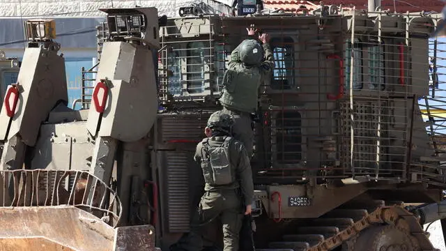 epa11924259 Israeli soldiers stand on an army bulldozer in the West Bank city of Jenin, 25 February 2025. The Israeli military launched a military operation in Jenin and its camp on 21 January, resulting in at least 27 Palestinian deaths and dozens of injuries, according to the Palestinian Ministry of Health. EPA/ALAA BADARNEH