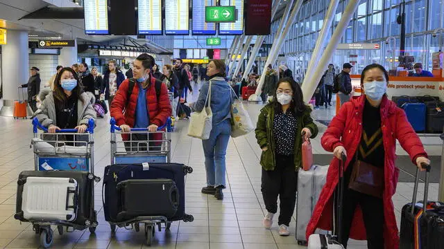 epa08188849 Travelers wear protective masks at Schiphol Airport, the Netherlands, 02 February 2020. Due to the outbreak of coronavirus, airline KLM is temporarily stopping flights to China. The outbreak of coronavirus has so far claimed over 250 lives and infected more than 11,000 others, according to media reports. The World Health Organization (WHO) has declared the coronavirus outbreak a global health emergency. EPA/EVERT ELZINGA