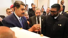 epa11191979 A handout photo made available by Prensa Miraflores shows the Presidents of Venezuela Nicolas Maduro (L) and of Guyana Irfaan Ali (R) in an exchange of gifts during a meeting in which they wished each other 'peace and love' within the framework of the 8th summit of the Community of Latin American and Caribbean States (CELAC) in Kingstown, Saint Vincent and the Grenadines, 01 March 2024. EPA/MIRAFLORES PRESS / HANDOUT ONLY AVAILABLE TO ILLUSTRATE THE ACCOMPANYING STORY/CREDIT MANDATORY HANDOUT EDITORIAL USE ONLY/NO SALES HANDOUT EDITORIAL USE ONLY/NO SALES