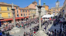 I cittadini che attendono, dietro le transenne, la visita della coppia reale tra bandierine italiane e britanniche e un drappo con l''Union Jack' con al centro l'effige della Regina Elisabetta, madre di Carlo, Ravenna, 10 aprile 2025. ANSA/Gianluca Angelini