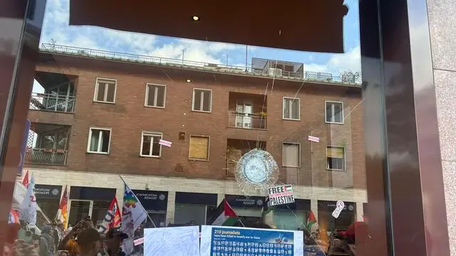 Danneggiata la vetrina di UniCredit in via Pola a Milano, dove sta passando il corteo nazionale per chiedere la fine della guerra a Gaza, 12 aprile 2025. "UniCredit complice del genocidio" hanno scritto con la vernice alcuni manifestanti, infrangendo il vetro, tanto che alcuni attivisti invitavano i presenti ad allontanarsi per il rischio che cadesse la vetrina. ANSA/FEDERICA ZANIBONI