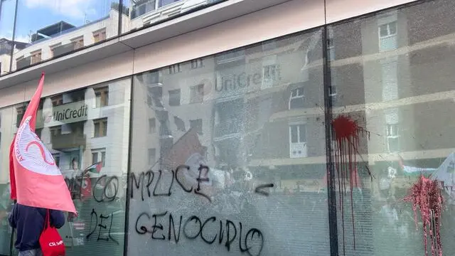 Danneggiata la vetrina di UniCredit in via Pola a Milano, dove sta passando il corteo nazionale per chiedere la fine della guerra a Gaza, 12 aprile 2025. "UniCredit complice del genocidio" hanno scritto con la vernice alcuni manifestanti, infrangendo il vetro, tanto che alcuni attivisti invitavano i presenti ad allontanarsi per il rischio che cadesse la vetrina. ANSA/FEDERICA ZANIBONI