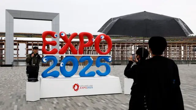 epa12029580 People take pictures as rain falls following the opening of Expo 2025 in Osaka, western Japan, 13 April 2025. Expo 2025 Osaka, Kansai, Japan will be open to the public until 13 October 2025. EPA/FRANCK ROBICHON