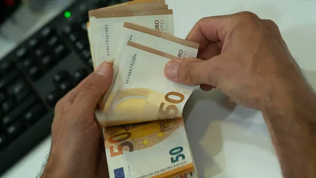 Un cassiere mentre conta banconote da 50 euro Danilo Schiavella/ANSA