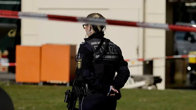 epa11938008 A police officer stands guard near the scene after a vehicle was driven into pedestrians in Mannheim, Germany, 03 March 2025. According to statements from police, a vehicle drove into a crowd in the Mannheim city centre, killing one person and injuring several others. EPA/RONALD WITTEK