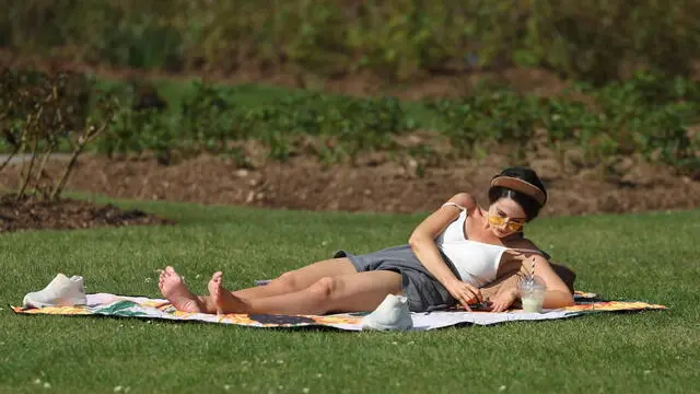 epa12009478 A person sits on the grass in the sunshine at the Regent's Park in London, Britain, 04 April 2025. The Met Office is predicting the hottest day of the year so far on 04 April. March 2025 was the sunniest in England since records began in 1910 and the rainfall total was just 43 percent of the usual amount. EPA/NEIL HALL