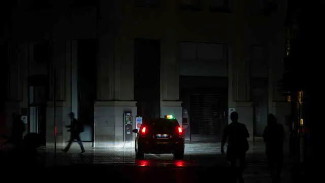 epa12061674 A person walks down a downtown street during a power outage in Málaga, Spain, 29 April 2025. EPA/Jorge Zapata
