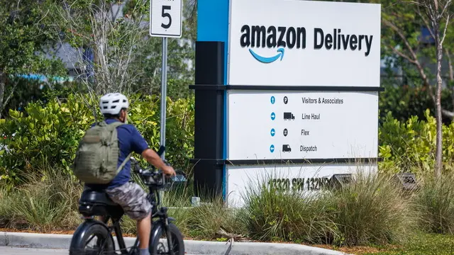 epa12060876 A person rides a bike in front of an Amazon logistic center in Miami, Florida, USA, 28 April 2025. Amazon is scheduled to share its first-quarter 2025 results on 01 May 2025, according to the company. EPA/CRISTOBAL HERRERA-ULASHKEVICH