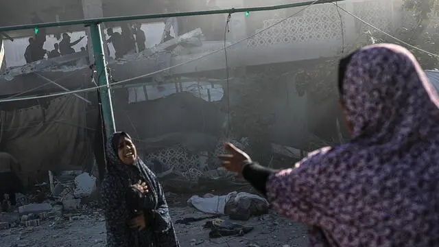 epa12054610 Two Palestinian women react near a body (R, rear) following an Israeli airstrike, at Al Farabi school in Gaza City, northern Gaza Strip, 25 April 2025. According to the Palestinian Ministry of Health in Gaza, at least three Palestinians were killed and 10 others wounded in Israeli airstrikes. EPA/MOHAMMED SABER