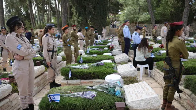 epa12064219 Israeli soldiers stand near the graves of fallen soldiers on the occasion of Israel's Memorial Day, at Mount Herzl national military cemetery in Jerusalem, 30 April 2025. Israel marks Memorial Day (Yom HaZikaron) in remembrance of its fallen soldiers and victims of terrorism. EPA/ABIR SULTAN
