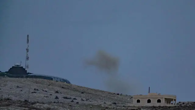 epa11762538 Smoke rises following an Israeli shelling next to a UN base on the Syrian side of the border, as seen from the Israeli-annexed Golan Heights, 07 December 2024. Israel's military said that an attack was carried out by armed individuals at a UN post in the Hader area in Syria, and that Israel was currently assisting the UN forces in repelling the attack. EPA/ATEF SAFADI