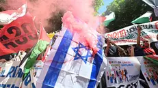 Attivisti bruciano bandiera europea usa e Israele al termine del corteo in piazza solferino a Torino, 1 maggio 2025 ANSA/ALESSANDRO DI MARCO
