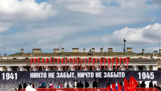 epa12069330 People walk on the Dvortsovaya (Palace) Square decorated with a panel depicting images of Russian veterans and reading 'No one is forgotten, nothing is forgotten', ahead of the Victory Day celebrations in St. Petersburg, Russia, 02 May 2025. Russia will mark on 09 May the 80th anniversary of the victory of the Soviet Union over Nazi Germany and its allies in World War II. EPA/ANATOLY MALTSEV