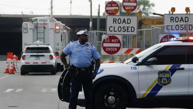 epa10687542 A police officer stands guards the scene of a southbound overpass of the I-95 Interstate in Philadelphia, Pennsylvania, USA, 12 June 2023. The adjoining section of the northbound I-95 Interstate collapsed on 11 June following a truck fire. Local authorities stated on 12 June that a body has been recovered from the scene. EPA/WILL OLIVER