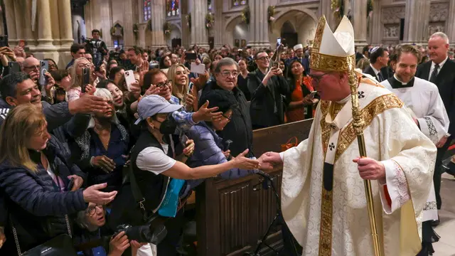 epa12047462 Archbishop of New York Timothy Dolan (R, front) interacts with members of the public following a mass for the repose of the soul of Pope Francis at St. Patrick's Cathedral in New York, New York, USA, 22 April 2025. Pope Francis died on 21 April 2025 at the age of 88, according to the Holy See. EPA/SARAH YENESEL