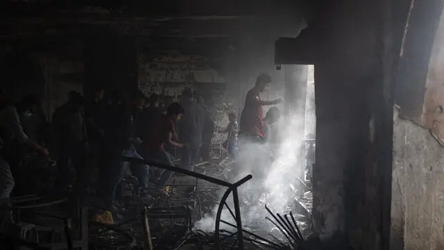 epa12048445 Displaced Palestinians inspect the damage to the Yaffa School following an Israeli airstrike, east of Gaza City, 23 April 2025. EPA/HAITHAM IMAD