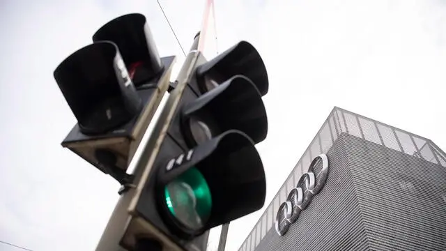 epa09081362 A traffic light shows green in front of an Audi AG logo at a companies dealership in Munich, Bavaria, Germany, 18 March 2021. The Ingolstadt-based carmaker held this year's annual press conference purely digitally. EPA/LUKAS BARTH-TUTTAS