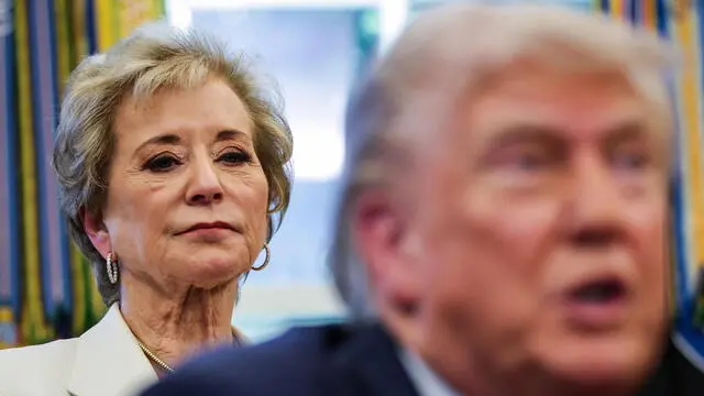 epa12050220 US Education Secretary Linda McMahon stands behind US President Donald Trump as he answers questions from reporters after he signed executive orders in the Oval Office at the White House in Washington, DC, USA, 23 April 2025. Trump signed seven executive orders on education policy, artificial intelligence, and school disciplinary policies. EPA/SAMUEL CORUM / POOL