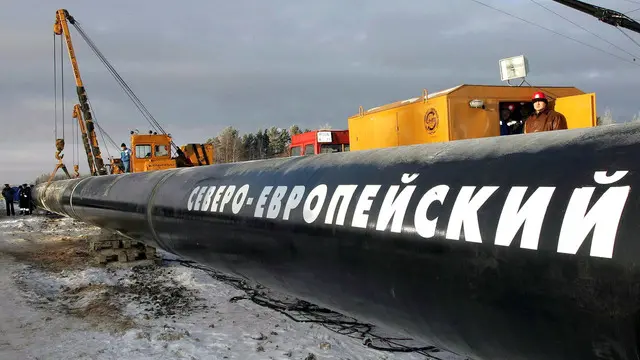 epa00592611 A worker watches as a segment of the Baltic Sea gas pipeline is laid near the town of Babayevo in the Vologda region some 650 km northeast of Moscow, Friday 09 December 2005. Russian gas company Gazprom has begun welding on the North European gas pipeline in the Vologda region. Gazprom plans to complete the construction of the first pipeline by July 2010. The two pipelines will have combined capacity of 55 billion cubic meters in 2013. The pipeline could eventually run via the Netherlands to Bacton in England, in which case it would be 3,000 km long. EPA/RIA-NOVOSTY NO ARCHIVES
