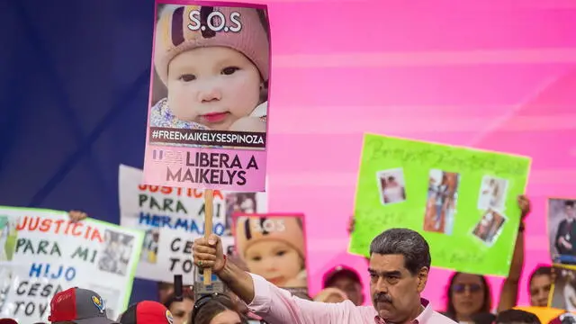 epa12068685 President of Venezuela Nicolas Maduro holds a placard featuring Maikelys Espinoza's image during a demonstration for International Workers' Day, in Caracas, Venezuela, 01 May 2025. Maduro held several opponents, including Maria Corina Machado, responsible for what may happen to the two-year-old girl that his government insists was separated from her mother before boarding a repatriation flight in the United States. EPA/MIGUEL GUTIERREZ