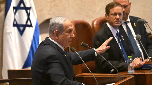 epa11689139 Israeli Prime Minister Benjamin Netanyahu (L) speaks at the opening of the 25th Knesset session as Israeli President Isaac Herzog (C) listens in Jerusalem, 28 October 2024. Israel opened its Knesset session marking the anniversary of the 'Swords of Iron' war, Israel's ground operations in the Gaza Strip. More than 43,000 Palestinians and over 1,400 Israelis have been killed, according to the Palestinian Health Ministry and the Israel Defense Forces (IDF), since Hamas militants launched an attack against Israel from the Gaza Strip on 07 October 2023, and the Israeli operations in Gaza and the West Bank which followed it. EPA/DEBBIE HILL / POOL