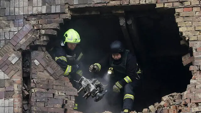 epa12079555 Ukrainian rescuers working at the site where a drone hit a high rise residential building in Kyiv, Ukraine, 07 May 2025, amid the ongoing Russian invasion. At least two people were killed and seven injured, including four children, in overnight strikes on multiple residential areas, according to the State Emergency Service. Russia launched a large-scale attack using at least four ballistic missiles and 142 drones across Ukraine. EPA/SERGEY DOLZHENKO