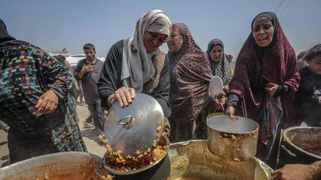 epa12086786 Internally displaced Palestinians gather to receive a portion of food from a charity kitchen, in Jabalia refugee camp, northern Gaza Strip, 09 May 2025. According to the UN Palestinian refugee agency UNRWA, over a million people across the Gaza Strip are experiencing 'high levels' of acute food insecurity, with acute malnutrition several times higher than before the war. The UN estimates at least 1.9 million people (nine in ten) are internally displaced. EPA/MOHAMMED SABER