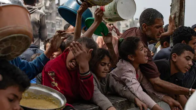 epa12051679 Internally displaced Palestinians push themselves in line to receive a portion of food from a charity kitchen, in Jabalia, northern Gaza Strip, 24 April 2025. According to the UN Palestinian refugee agency UNRWA, over a million people across the Gaza Strip are experiencing 'high levels' of acute food insecurity, with acute malnutrition several times higher than before the war. The UN estimates at least 1.9 million people (nine in ten) are internally displaced. EPA/HAITHAM IMAD