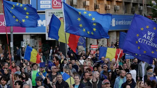 epa12087821 People march on Magheru Boulevard with signs and EU flags during a pro-European rally ahead of the 18 May 2025 presidential runoff elections in downtown Bucharest, Romania, 09 May 2025. Thousands of people, including civil rights activists, gathered to support the European Union's core values after sovereignist candidate George Simion finished in first place during the first round of the presidential election re-run elections. Romanians celebrate Europe Day, also known as Schuman Day from the date of the Schuman Declaration, held on 09 May every year, celebrating peace and unity in Europe. EPA/ROBERT GHEMENT