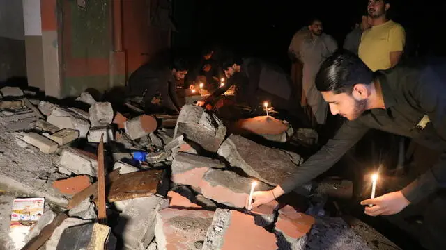 epa12087339 People attend a candlelight vigil in remembrance of the victims in front of the damage following India's missile strike on Bilal Mosque in Muzaffarabad, the capital of Pakistani-administered Kashmir, Pakistan, 09 May 2025. According to Pakistan's Director General of Inter-Services Public Relations, at least 31 Pakistani civilians were killed and 57 others injured in Indian aerial attacks. EPA/AMIRUDDIN MUGHAL