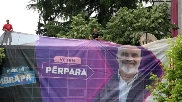 epa12087670 Men set up giant banner depicting Albania's Prime Minister Edi Rama, the chairman of the Socialist Party of Albania (PS) ahead of the pre-election rally in Tirana, Albania, 09 May 2025. Parliamentary elections in Albania are scheduled for 11 May 2025, with around 3.9 million eligible voters from both within the country and the diaspora set to elect 140 members of Parliament. EPA/MALTON DIBRA