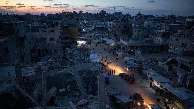 epaselect epa11834340 Palestinians walk through a market in Khan Younis, southern Gaza Strip, 18 January 2025. A ceasefire between Israel and Hamas will take effect on 19 January 2025. More than 46.000 people have been killed in Gaza since October 2023, when Israel launched a military campaign in response to a cross-border attack by Hamas, in which about 1,200 people were killed and over 200 taken hostage. EPA/HAITHAM IMAD