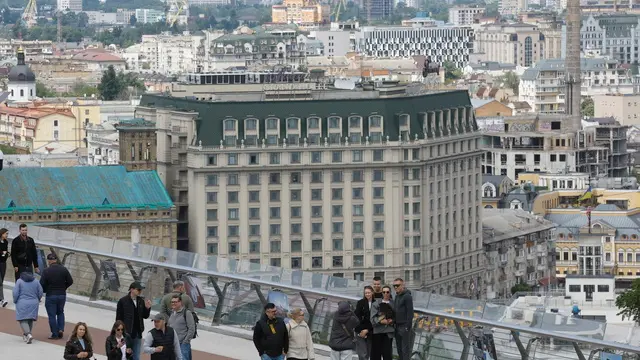 epa12091501 People walk across a bridge in downtown Kyiv, Ukraine, 11 May 2025, amid the ongoing Russian invasion. EPA/SERGEY DOLZHENKO