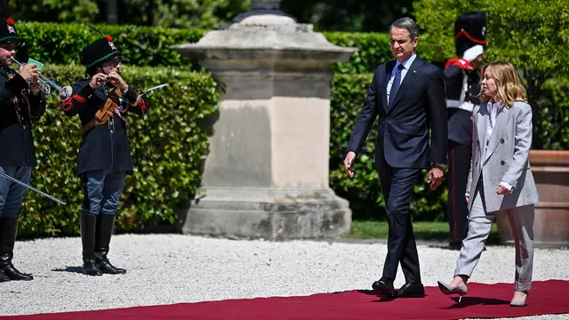 epa12093600 Italian Prime Minister Giorgia Meloni (R) and Greek Prime Minister Kyriakos Mitsotakis (2-R) inspect the guard of honor at Villa Pamphili ahead of the Italy-Greece Intergovernmental Summit in Rome, Italy, 12 May 2025. EPA/RICCARDO ANTIMIANI