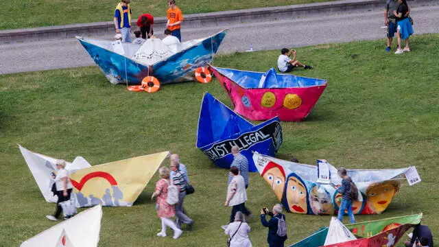 epa11425151 Oversized origami boats are placed on the field at the Lustgarten square in Berlin, Germany, 20 June 2024. Workers' welfare organization AWO Saxony-Anhalt initiated a day of action on the occasion of the World Refugee Day and to set a sign for a diverse civil society and solidarity with over 110 million refugees. EPA/CLEMENS BILAN