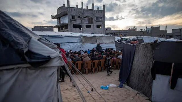 epa11940253 Palestinians gather near their tents to break their fast together on the fourth day of the holy month of Ramadan in Khan Younis, southern Gaza Strip, 04 March 2025. EPA/HAITHAM IMAD