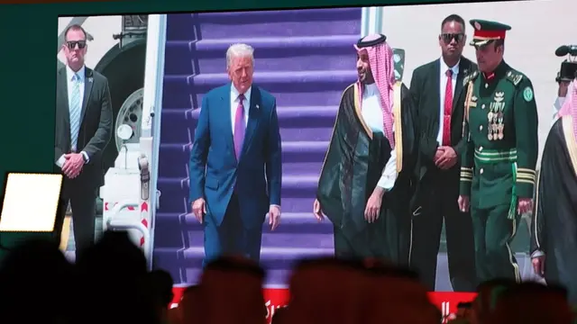 epa12095509 A screen shows Saudi Crown Prince Mohammed Bin Salman welcoming US President Donald Trump after landing in Riyadh, during the Saudi-US Investment Forum in Riyadh, Saudi Arabia, 13 May 2025. The forum is taking place during the state visit of US President Donald Trump to Saudi Arabia on 13 May. EPA/ALI HAIDER