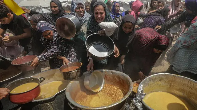 epa12086532 Internally displaced Palestinians gather to receive a portion of food from a charity kitchen, in Jabalia refugee camp, northern Gaza Strip, 09 May 2025. According to the UN Palestinian refugee agency UNRWA, over a million people across the Gaza Strip are experiencing 'high levels' of acute food insecurity, with acute malnutrition several times higher than before the war. The UN estimates at least 1.9 million people (nine in ten) are internally displaced. EPA/MOHAMMED SABER