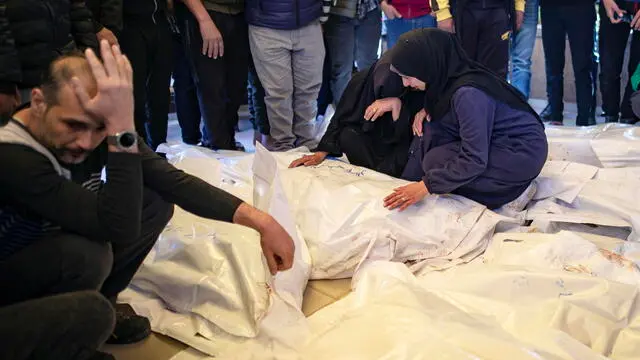 epa12024217 Relatives of victims from the Palestinian Al-Farra family mourn over their covered bodies at Nasser Hospital in Khan Yunis, south of the Gaza Strip, 11 April 2025. Ten members of the family were killed after their home was targeted by the Israeli army in Khan Yunis. More than 50,800 Palestinians have been killed in the Gaza Strip, according to the Palestinian Ministry of Health, since Israel launched a military campaign in the strip in response to a cross-border attack led by the Palestinian militant group Hamas on 07 October 2023, in which about 1,200 Israelis were killed and more than 250 taken hostages. EPA/HAITHAM IMAD