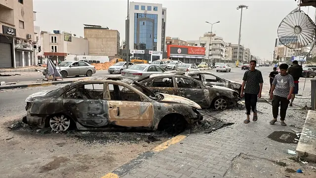 epa12099537 Damaged cars pictured in the street after clashes in Tripoli, Libya, 14 May 2025. Flights at Mitiga Airport were suspended due to clashes while the Ministry of Education had suspended classes in schools in the capital. EPA/STRINGER